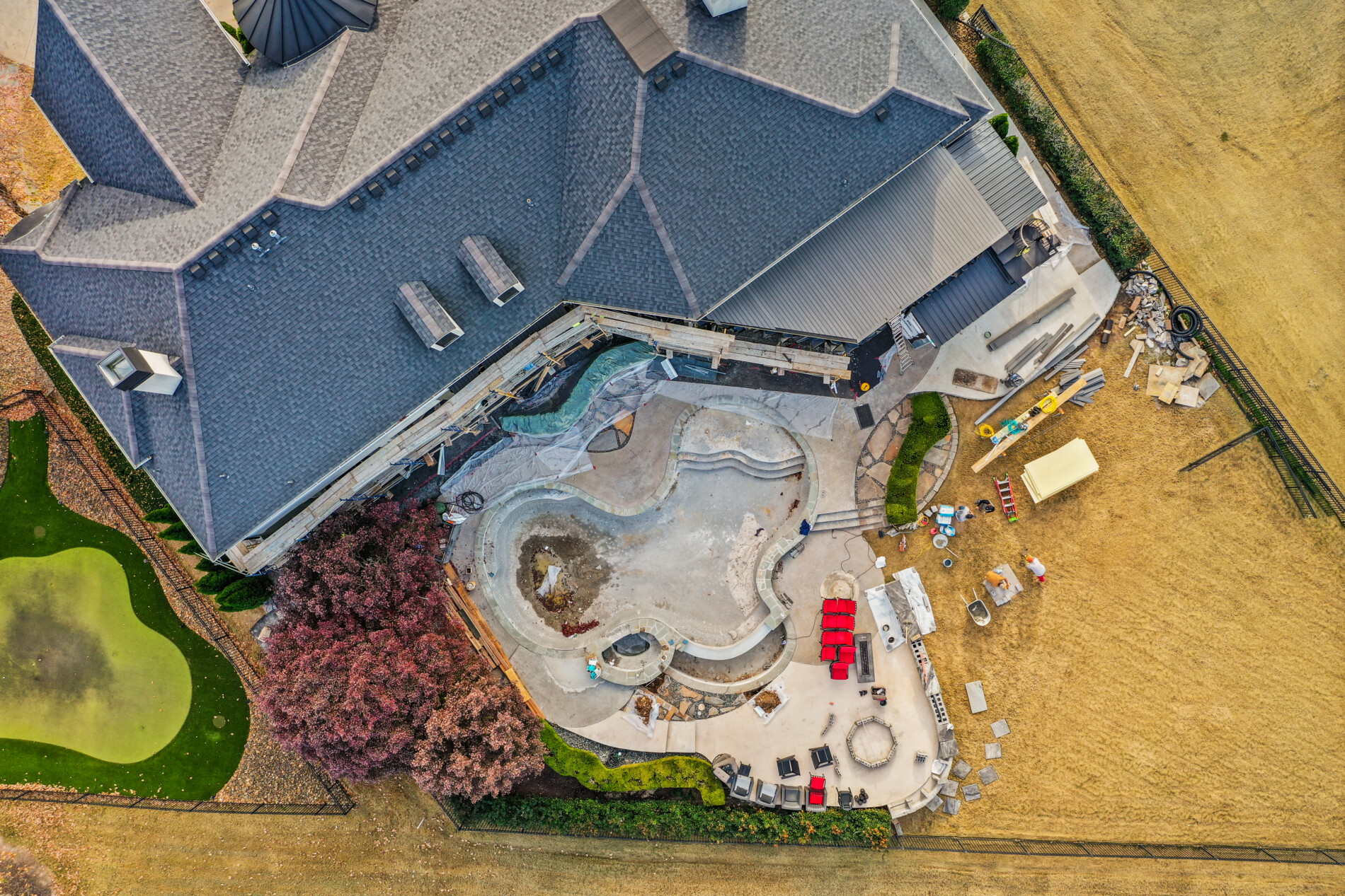 Overhead drone photo showing detailed progress on the Shadow Valley pool renovation, with shaped basins, equipment, and work zones throughout the site.